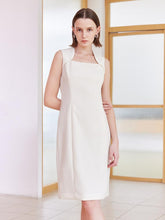 A woman with short hair is wearing a white dress.